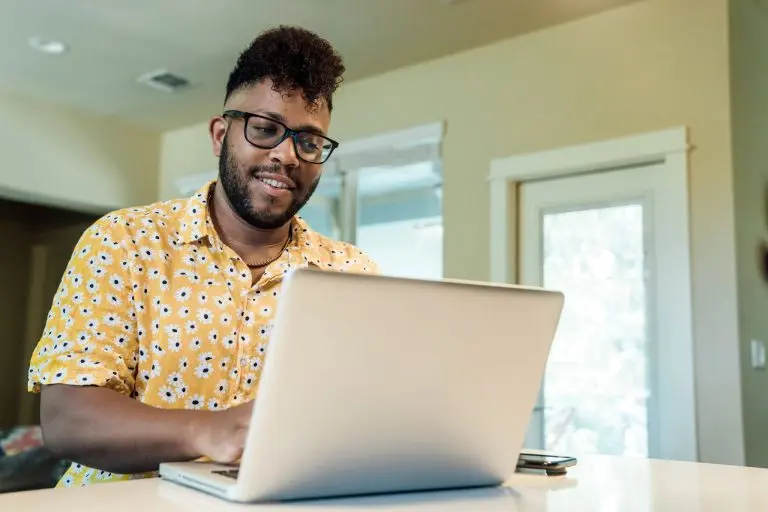 smiling person using laptop